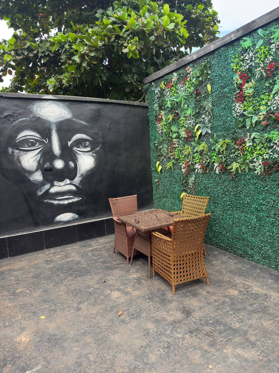 Nova Arena outdoor seating beside a portrait mural and greenery wall